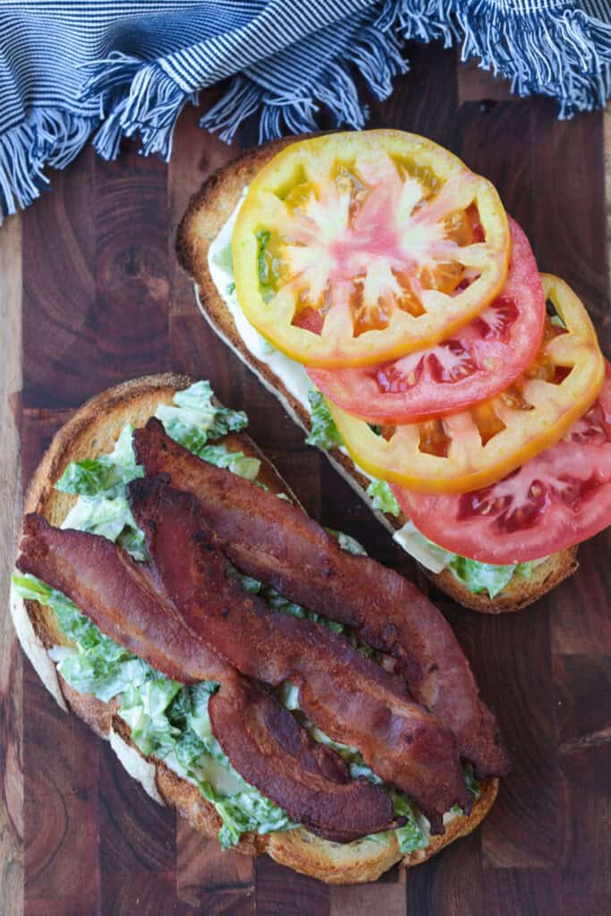 open blt sandwich on wooden board