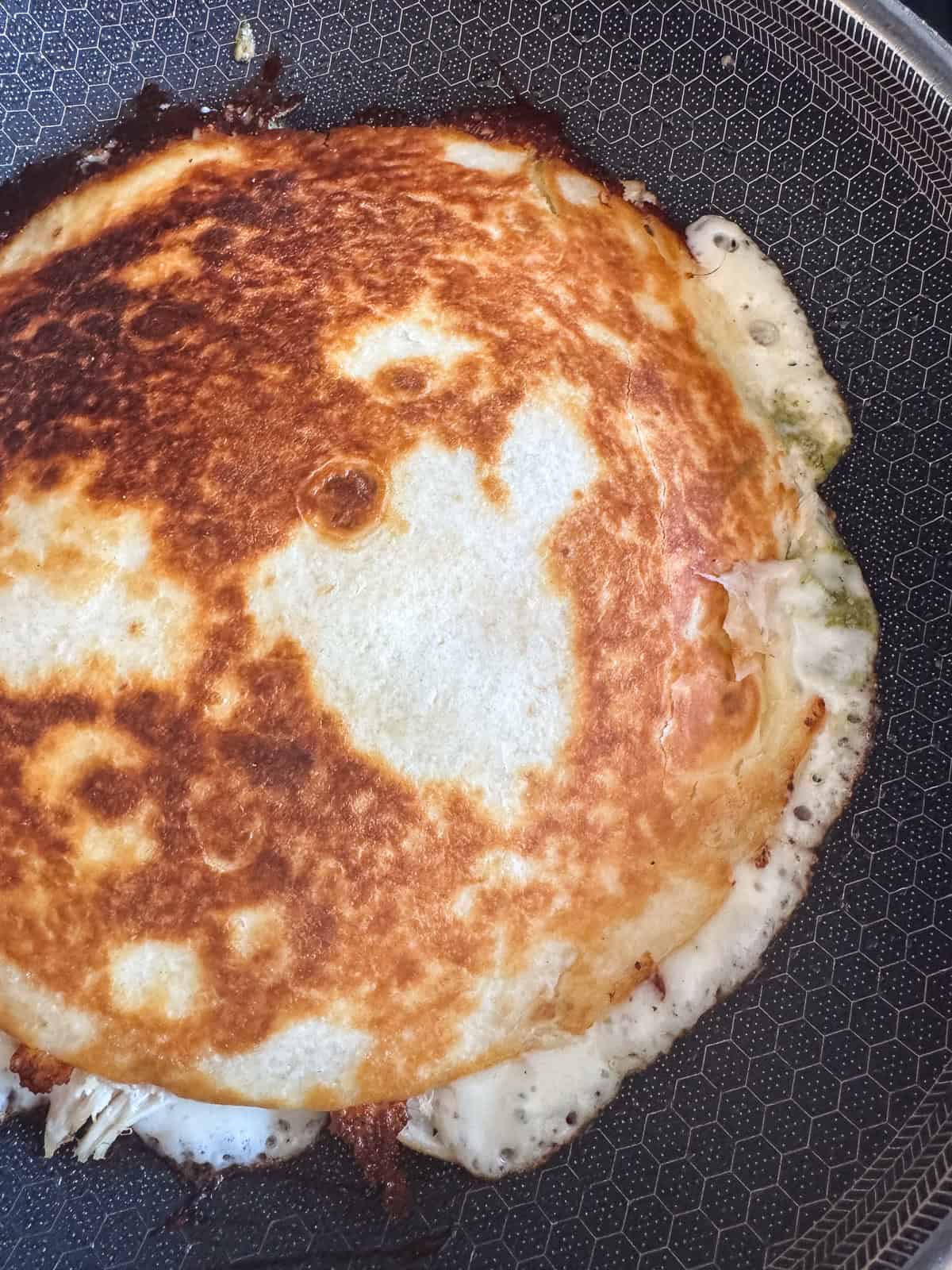 Crispy Chicken Zucchini Quesadillas are filled with tender chicken, thinly sliced zucchini and gooey cheese for an easy 30 minute dinner. browned quesadilla in a skillet with melted cheese