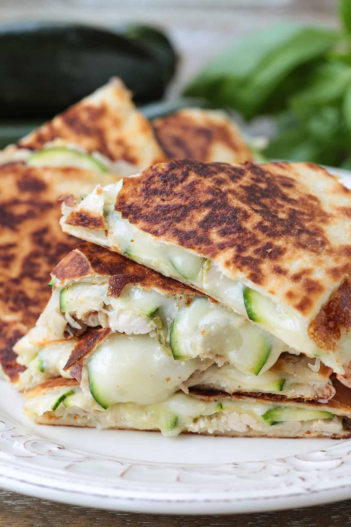 Crispy Chicken Zucchini Quesadillas are filled with tender chicken, thinly sliced zucchini and gooey cheese for an easy 30 minute dinner. chicken zucchini quesadillas cute and stacked on a plate