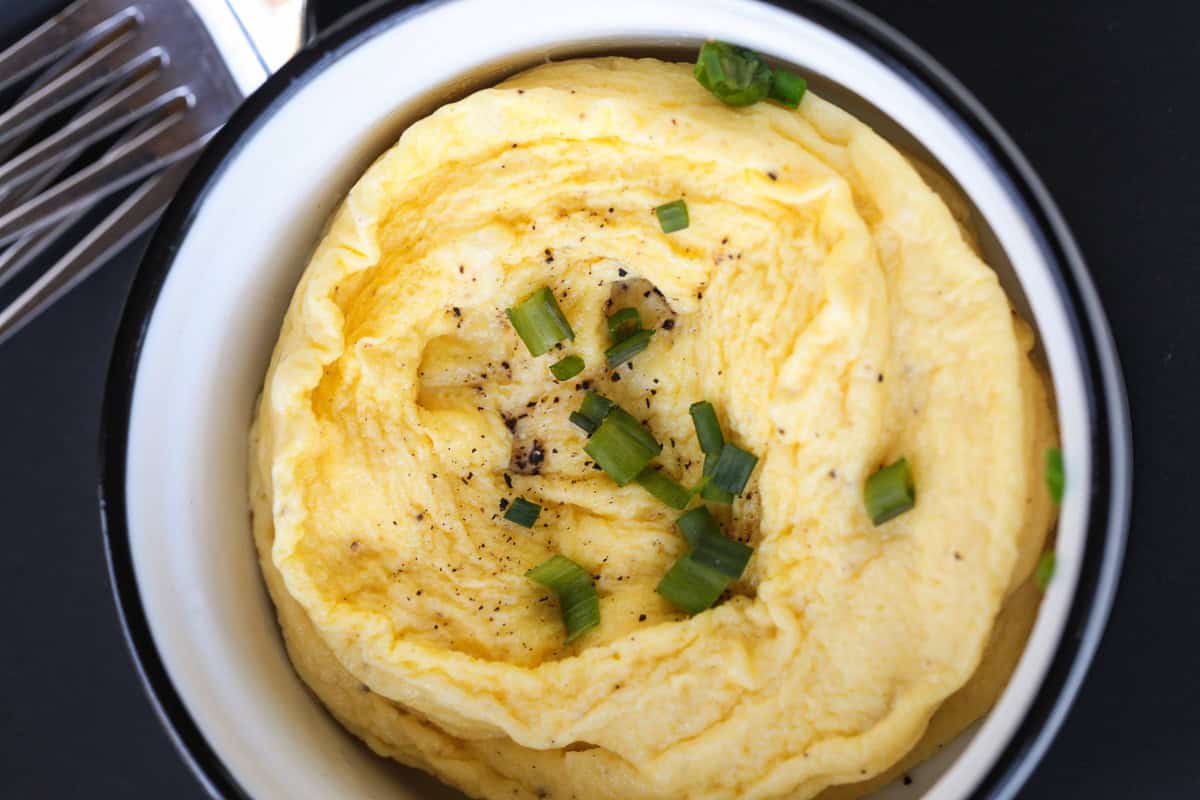 scrambled eggs in a white ramekin with chives