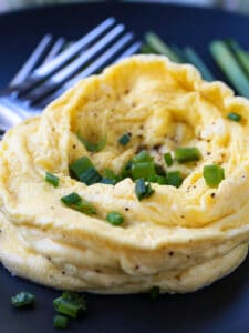 microwave scrambled eggs on a black plate with forks