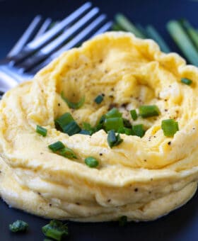 microwave scrambled eggs on a black plate with forks