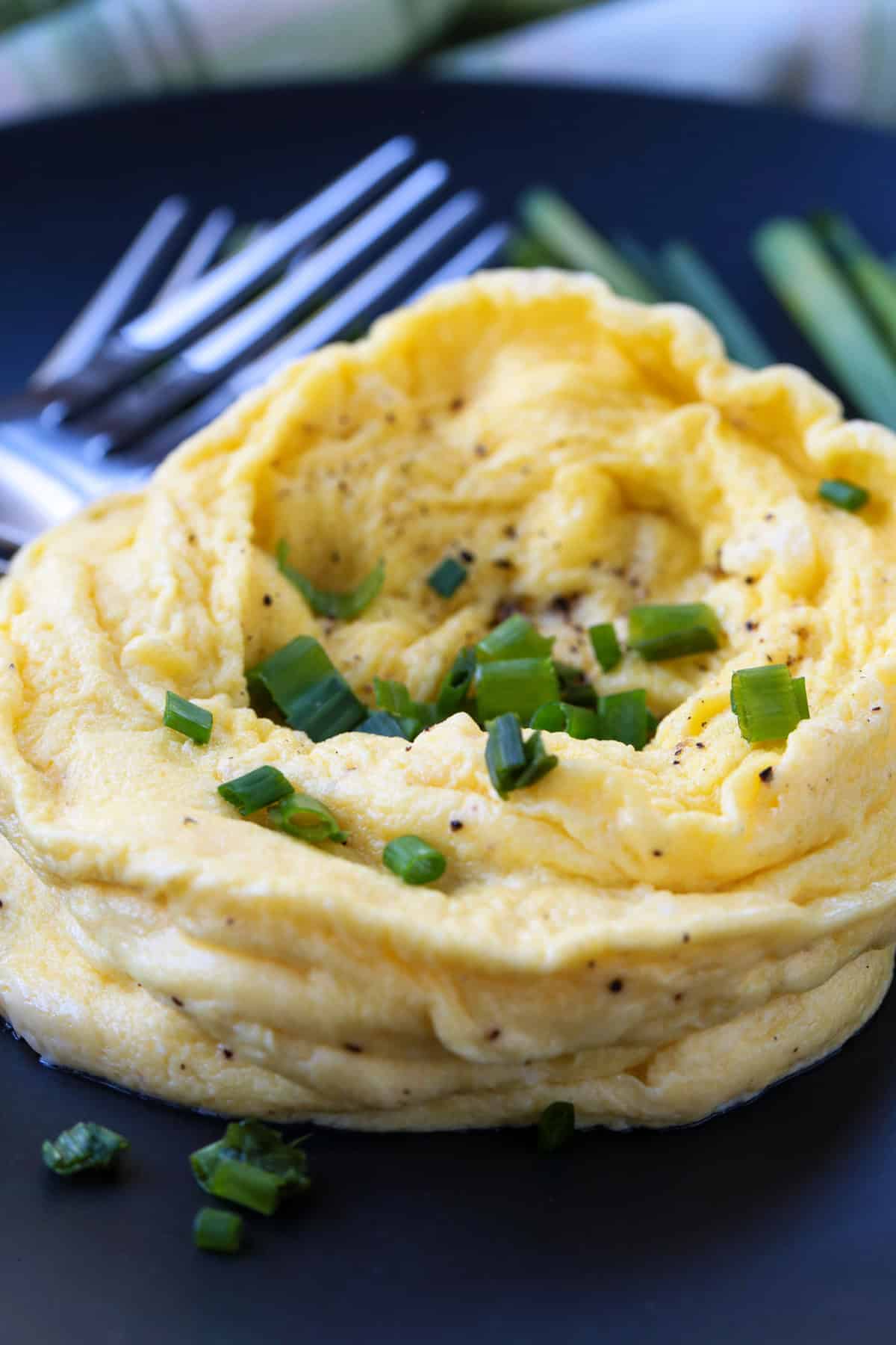 microwave scrambled eggs on a black plate with forks
