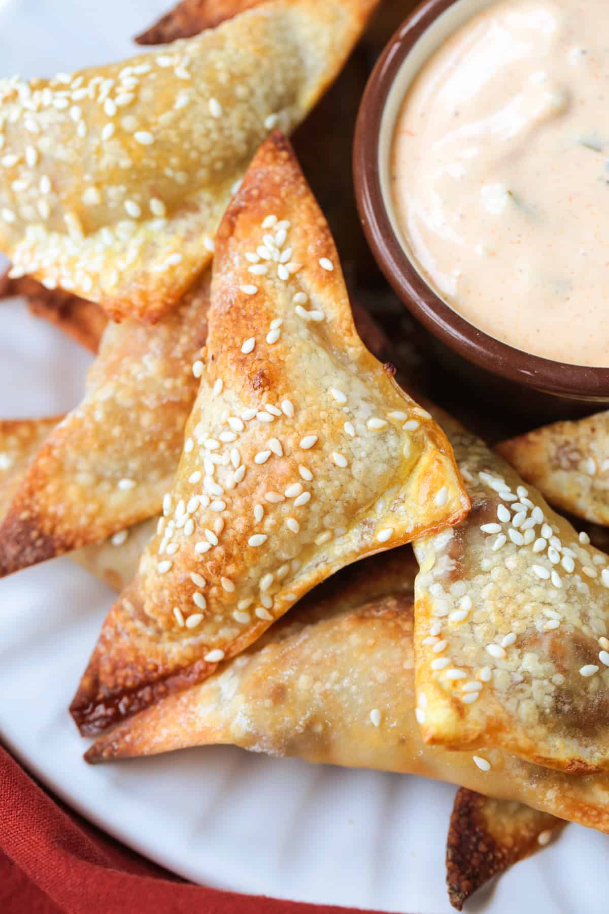 Cheeseburger Wontons are sure to become a new favorite! A beefy, cheesy filling stuffed into crispy wontons and dipped in our big mac sauce! cheeseburger wontons on a plate with sauce on the side