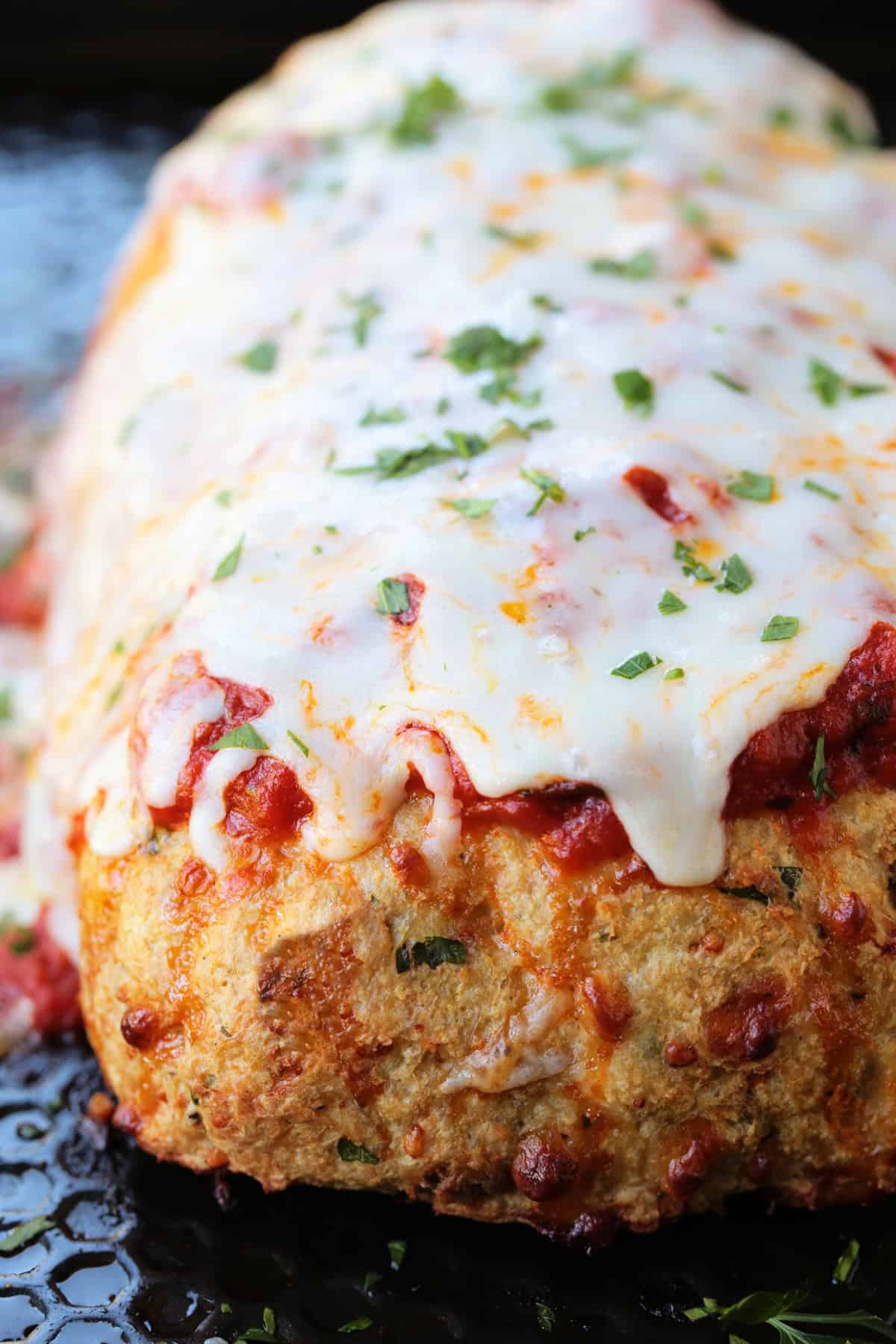 Chicken Parmesan Meatloaf has all the flavors of the classic dish. Juicy and flavorful meatloaf smothered with sauce and mozzarella cheese! whole chicken parmesan meatloaf on a sheet pan