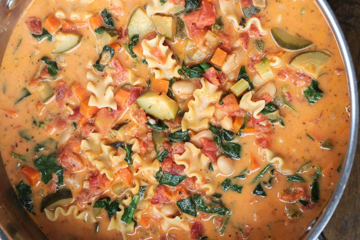 minestrone soup in a pot with pasta and a creamy broth