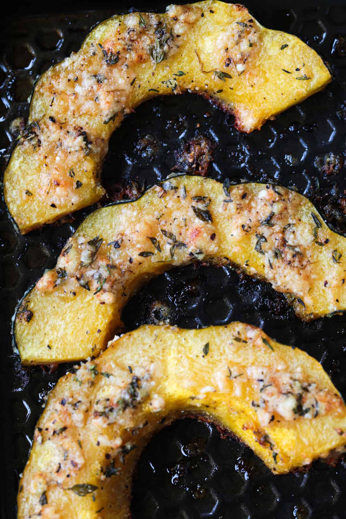 Roasted Parmesan Acorn Squash is so easy to make! Nutty parmesan cheese with fresh thyme is hands down a winning flavor combination. sliced and roasted acorn squash on a baking sheet