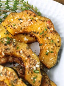 acorn squash sliced and roasted on a platter