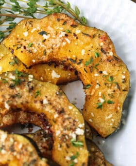 acorn squash sliced and roasted on a platter